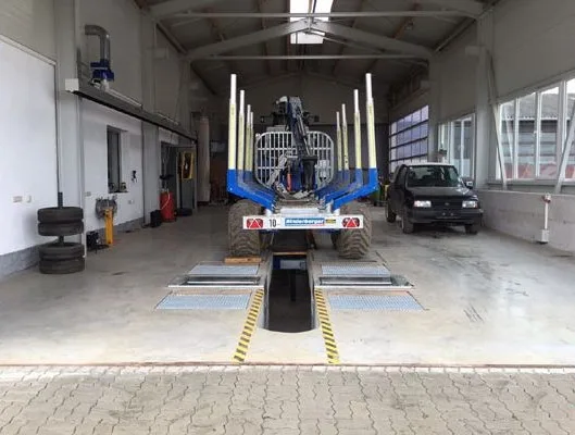 Werkstatthalle mit Prüfgrube, darin ein Rückewagen und ein Geländewagen