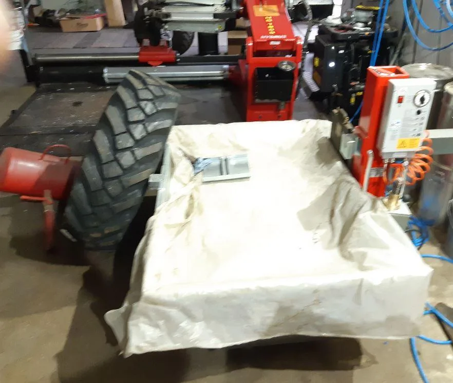 Traktorreifen in der Vulkanisierungsanlage, abgedeckt mit einer weißen Plane